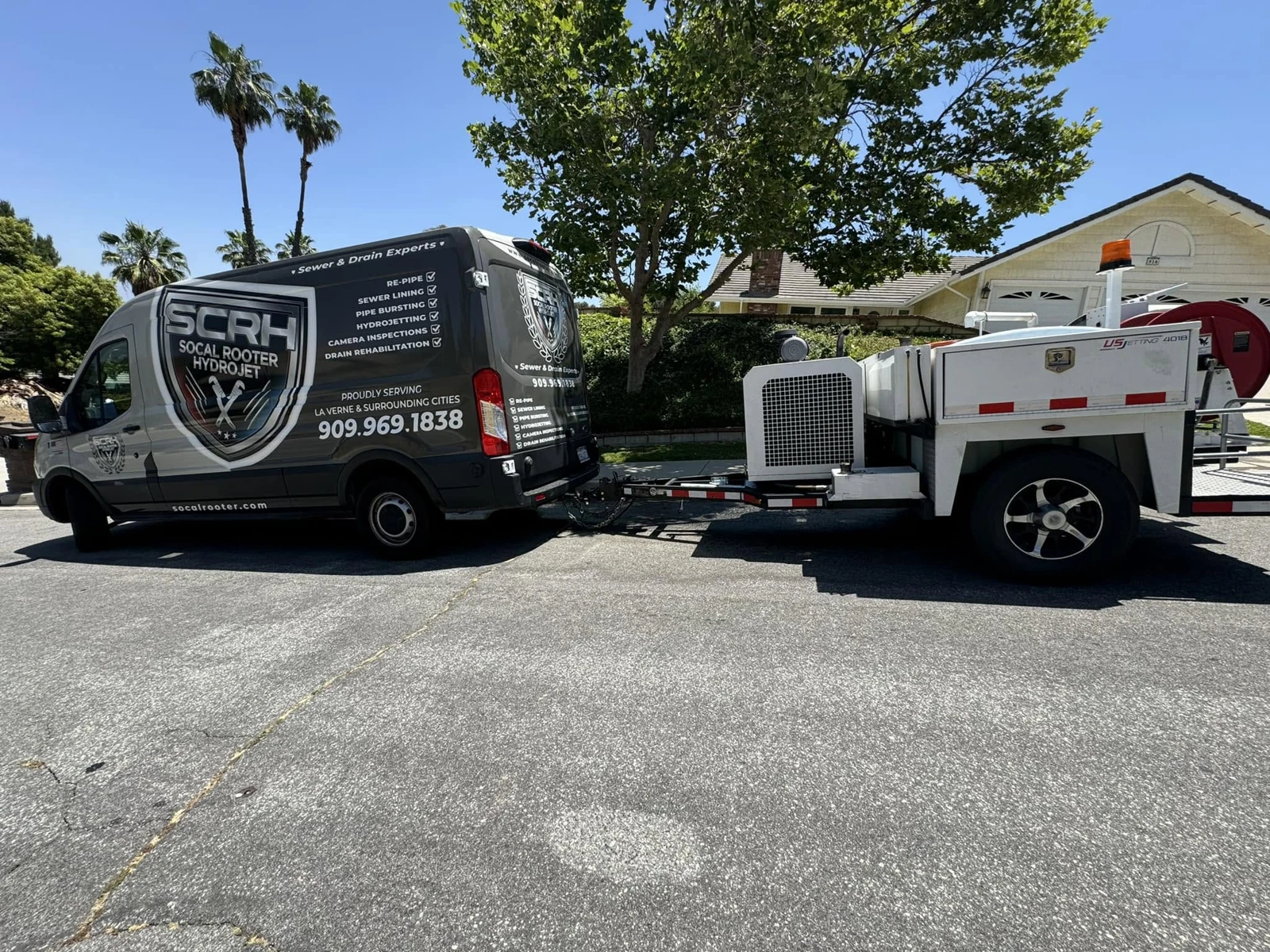 The SoCal Rooter branded service van and hydrojet trailer on a Southern California street